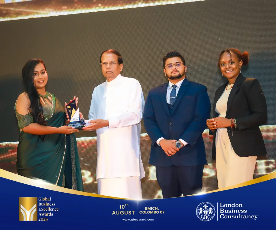 A woman receiving an award on stage at the Global Business Excellence Awards