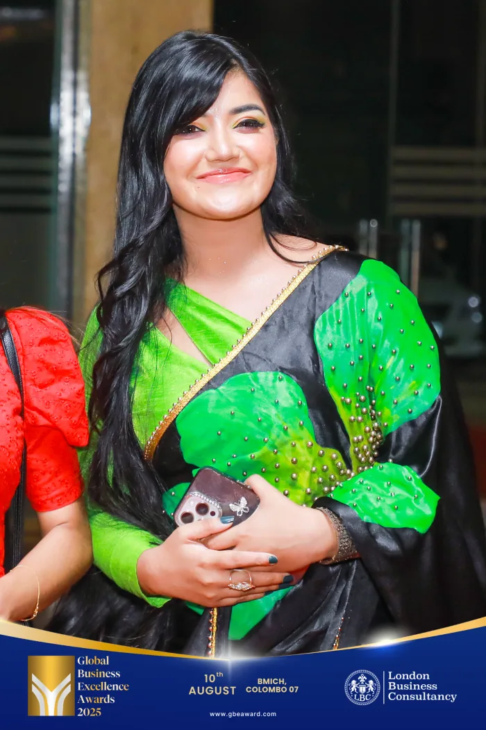 A woman in a green and black sari at the Global Business Excellence Awards event